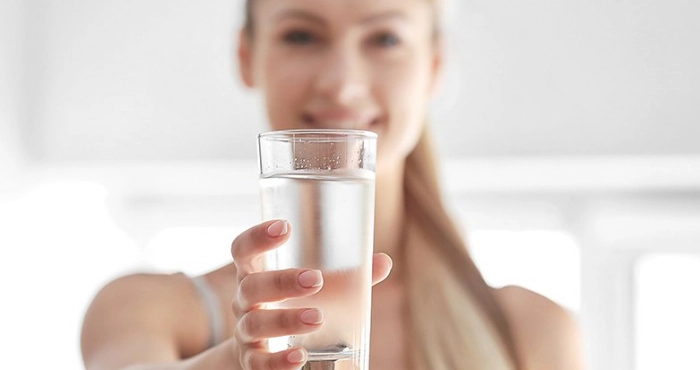 Persona che beve acqua in modo corretto per la salute